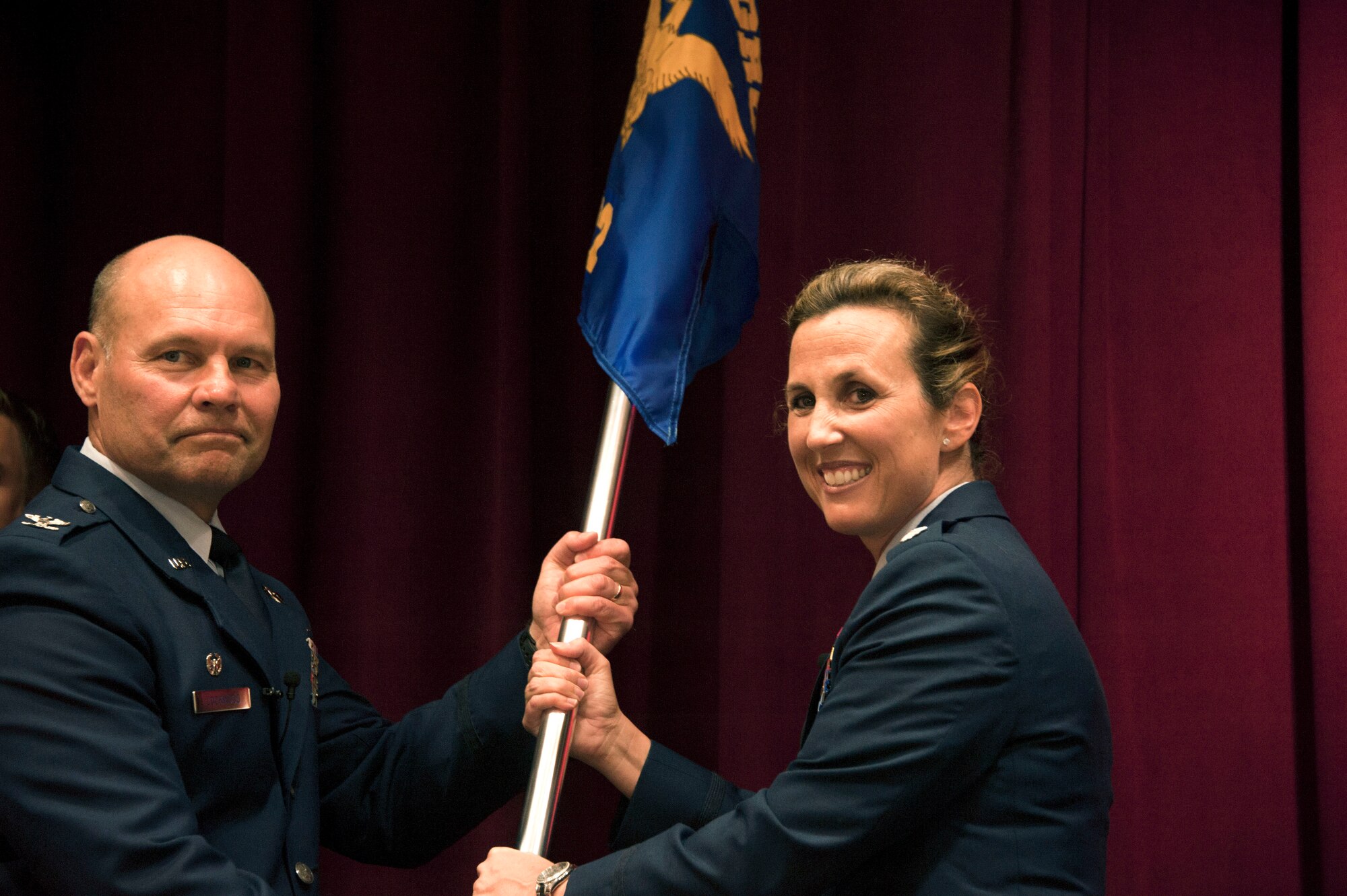 Col. Scott Lockwood, commander, Air Force Officer Training School, transfers command of Detachment 12 to Lt. Col. Loralie Rasmussen during a change of command ceremony July 16, 2015, Maxwell Air Force Base, Alabama. Rasmussen took command of the detachment from her husband, Lt. Col. Reid Rasmussen, who is attending Air War College here. (U.S. Air Force photo by Airman 1st Class Alexa Culbert)