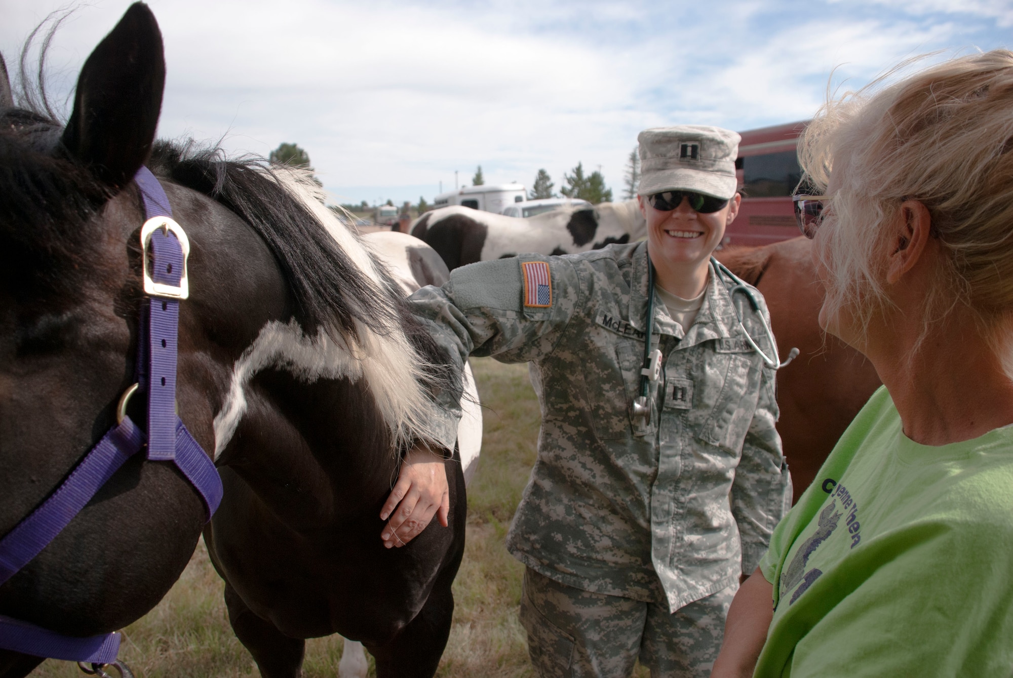 Army Capt. Shannon Mclean pets Stanley during his examination while speaking with his owner Anita Lafond on July 17, 2015 at Fort D.A. Russell Days. Army Staff Sgt. Seth Williams, Veterinary Treatment Facility non-commissioned officer in charge, assisted Mclean during the examinations. (U.S. Air Force photo by Katherine Oriez)