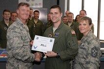 Capt. David Sullivan, center, 85th Flying Training Squadron flight commander and T-6 instructor pilot, poses with Col. Thomas Shank, 47th Flying Training Wing commander, and Chief Master Sgt. Teresa Clapper, 47th FTW command chief, after accepting the XLer of the Week award, here, July 15, 2015. The XLer is a weekly award chosen by wing leadership and is presented to those who consistently make outstanding contributions to their unit and Laughlin. (U.S. Air Force photo by Airman 1st Class Brandon May)