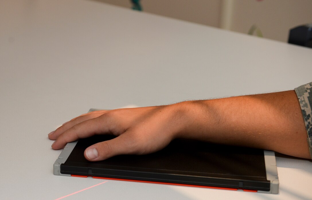 A patient places his wrist on an imaging plate before getting X-rays at the 22nd Medical Support Squadron’s radiology department at McConnell Air Force Base, Kan., July 20, 2015. The radiology Airmen ensure Team McConnell stays healthy by producing the highest quality images for X-ray, ultrasound, mammography and bone density examinations to assist healthcare providers in diagnostic treatment. (U.S. Air Force photo by Senior Airman Colby Hardin)