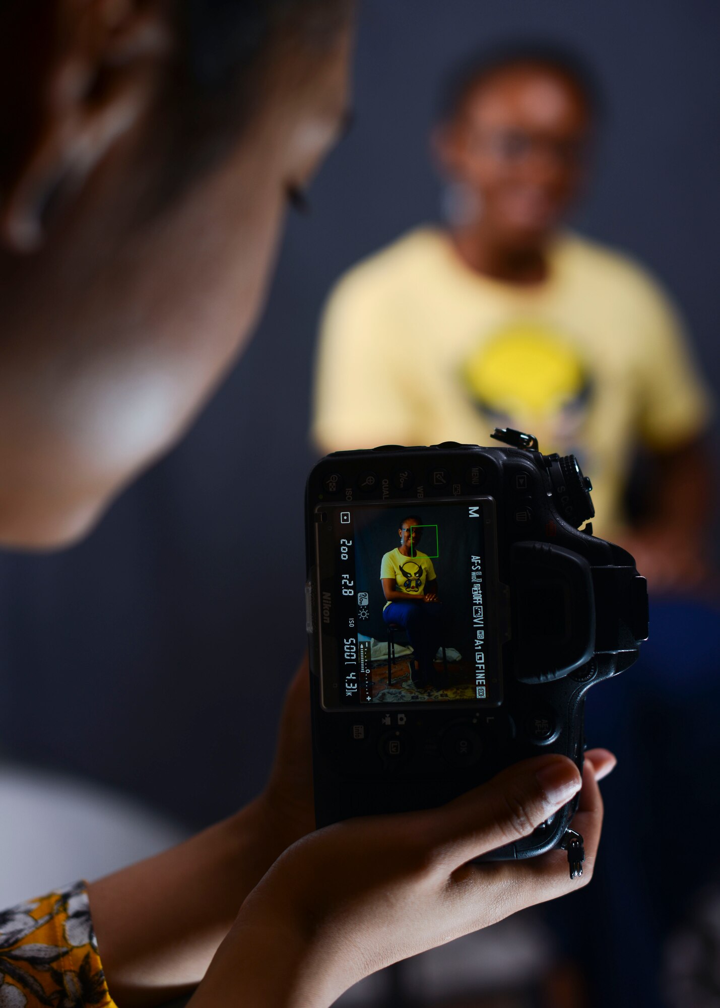 Mercedes Mendez, 31st Force Support Squadron cashier, takes a photo, July 23, 2015, at Aviano Air Base, Italy. The Arts and Crafts Store has a self-help photo studio available for customers. (U.S. Air Force photo by Senior Airman Austin Harvill/Released)