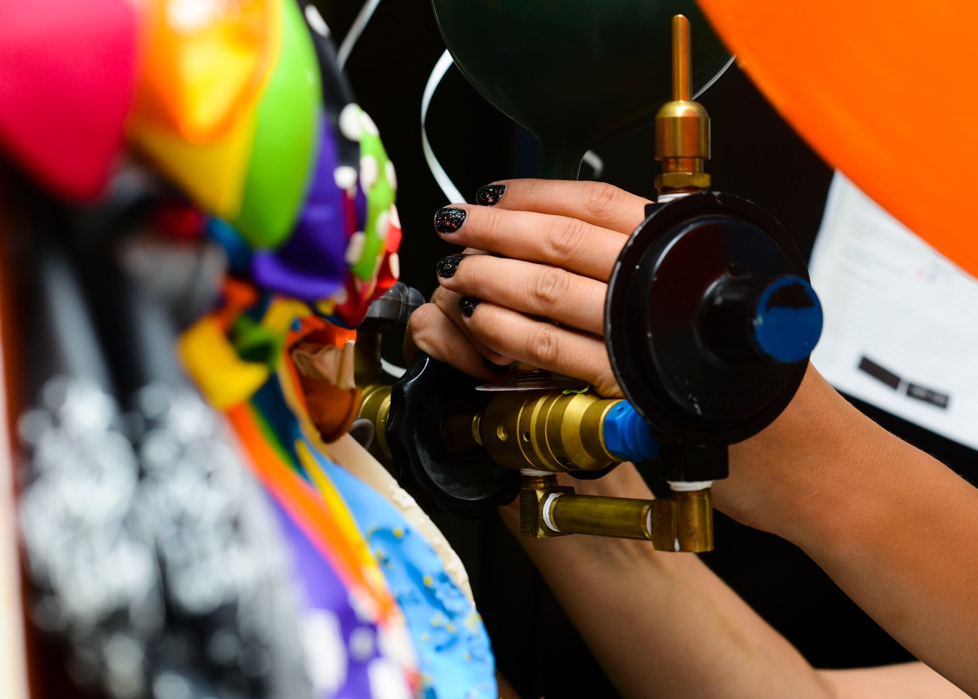 Brittany Blaes, 31st Force Support Squadron cashier, fills balloons at the Arts and Crafts Store, July 21, 2015, at Aviano Air Base, Italy. In addition to balloons, the store has a variety of arts and crafts supplies for sale. (U.S. Air Force photo by Senior Airman Austin Harvill/Released)