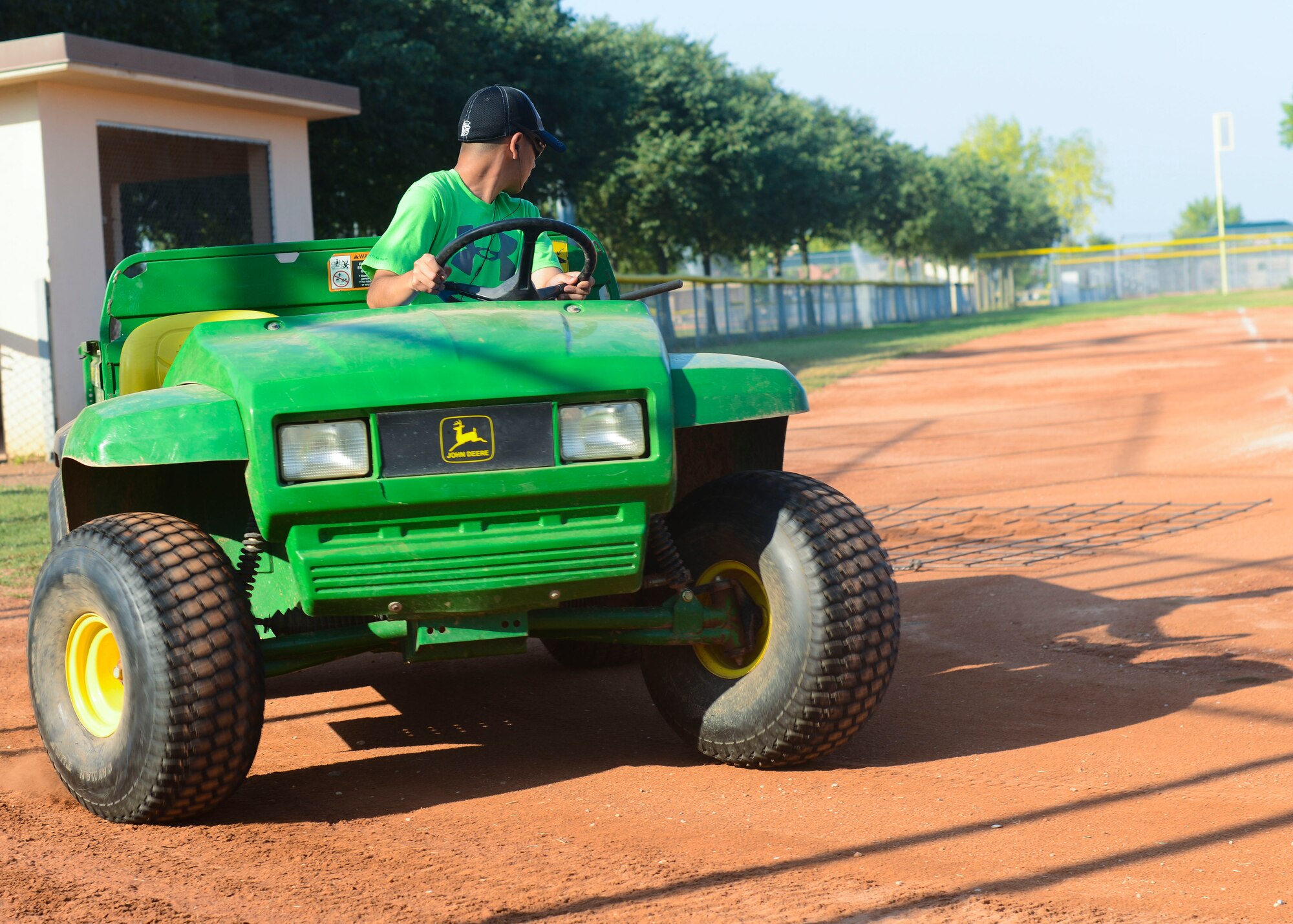 Victor Antillon, Summer Hire Program employee and son of U.S. Air Force Master Sgt. Jesus Antillon, drags a grate over a baseball field to smooth the turf, July 20, 2015, at Aviano Air Base, Italy. Program employees either work as laborers or clerks, performing duties such as yard work, customer service and equipment management. (U.S. Air Force photo by Senior Airman Austin Harvill/Released)