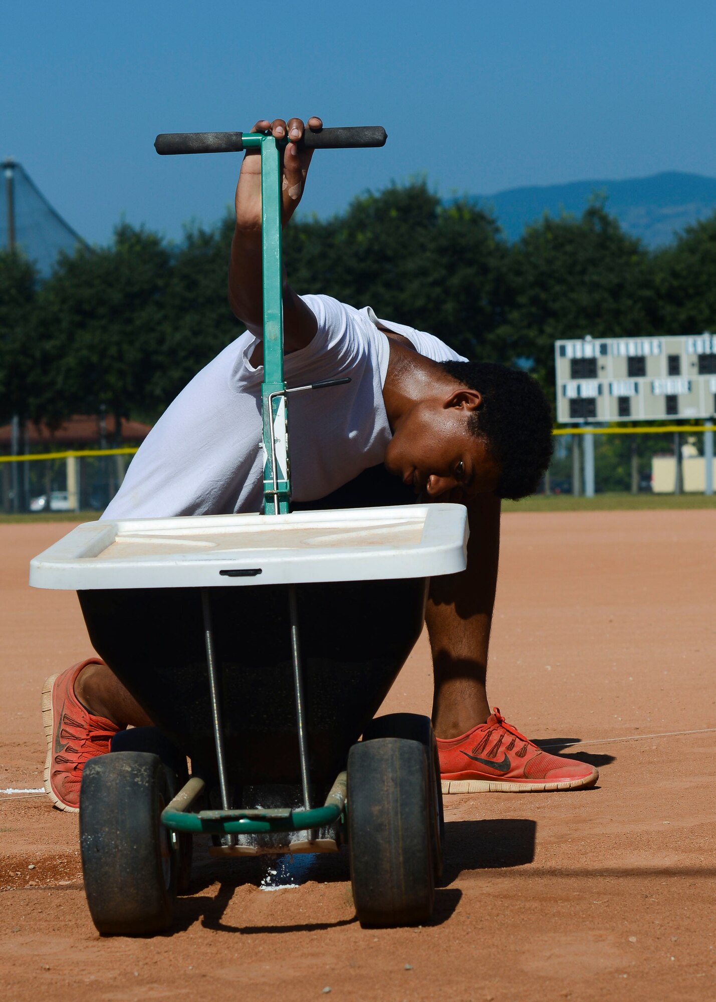 Jaylen Esposito, Summer Hire Program employee and son of U.S. Air Force Master Sgt. Justin Esposito, ensures a batter’s box is straight, July 20, 2015, at Aviano Air Base, Italy. Only Team Aviano teens have the opportunity to take part in the program. (U.S. Air Force photo by Senior Airman Austin Harvill/Released)