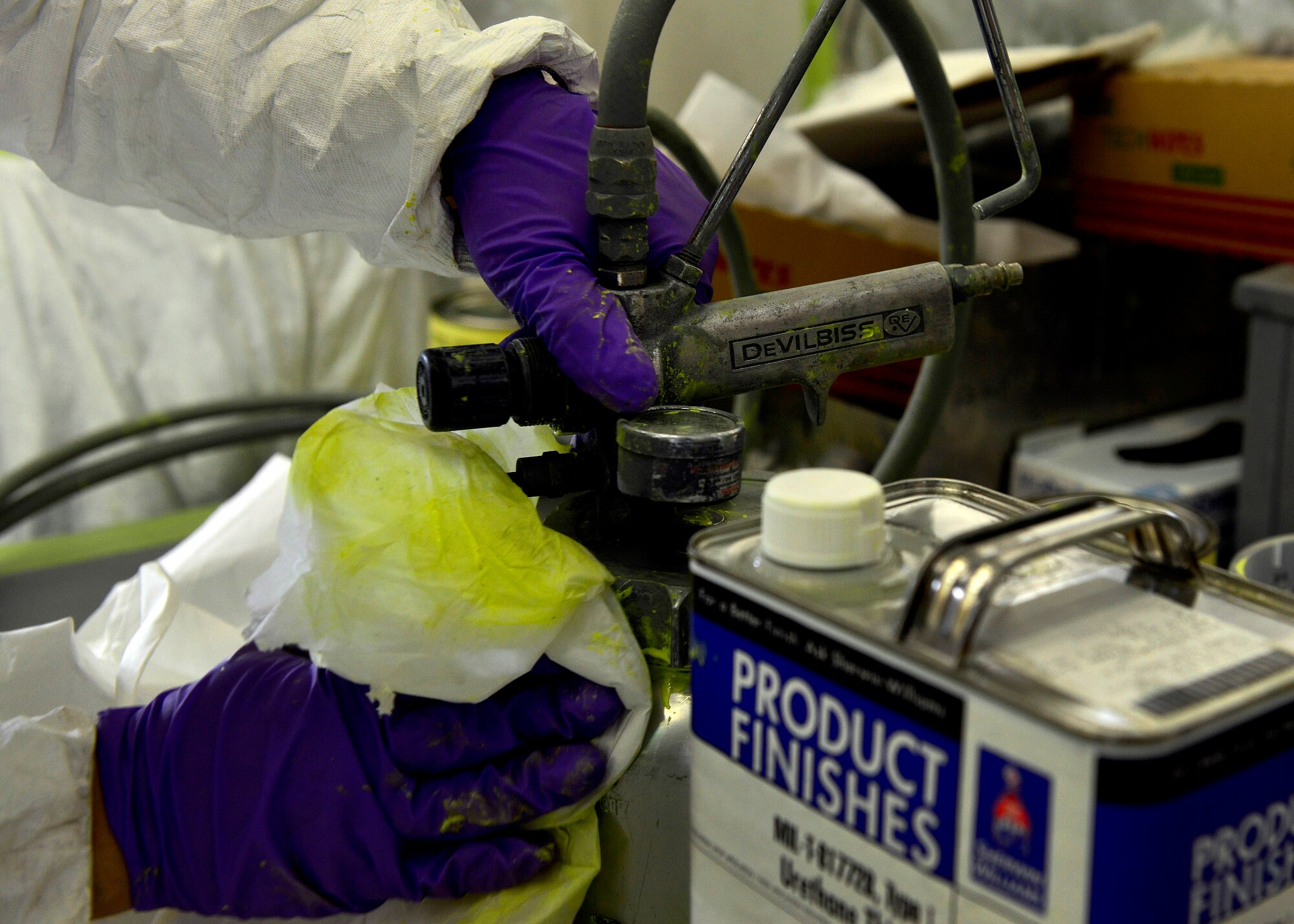 Corrosion control specialists fill a spray container to paint an F-16 Fighting Falcon, July 16, 2015, at Aviano Air Base, Italy. An aircraft’s body is sprayed with a chemical coat of primer and then a top coat every four to six years to prevent corrosion from occurring. (U.S. Air Force photo by Airman 1st Class Cary Smith/Released)