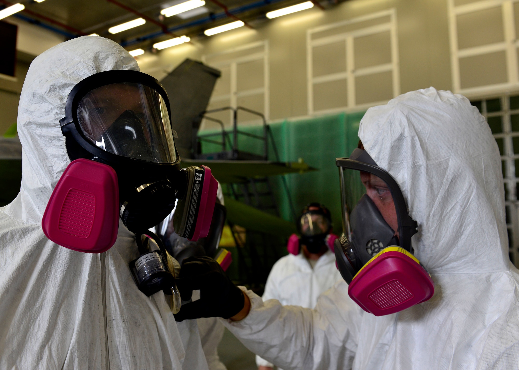 U.S. Air Force Senior Airman Bryce Cook, 31st Aerospace Medical Squadron bioenvironmental engineering technician, secures Airman Justin King’s, 31st Maintenance Squadron aircraft structural maintenance apprentice, gas mask before painting an aircraft, July 16, 2015, at Aviano Air Base, Italy. An aircraft’s body is sprayed with a chemical coat of primer and then a top coat every four to six years to prevent corrosion from occurring. (U.S. Air Force photo by Airman 1st Class Cary Smith/Released) 