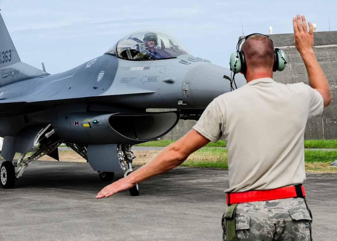 U.S. Air Force Master Sgt. David Custer, Vermont Air National Guard’s 158th Maintenance Squadron lead crew chief, martials a U.S. Air Force F-16 Fighting Falcon into its parking space on Kadena Air Base, Japan, July, 22, 2015. The 158th ANG Fighter Wing is providing a theater security package throughout the Indo-Asia-Pacific region. (U.S. Air Force photo by Airman 1st Class John Linzmeier) 