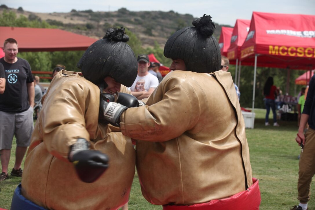 Marines grapple in sumo wrestler costumes at the 1st Intelligence Battalion family fun day aboard Marine Corps Base Camp Pendleton, Calif., July 1, 2015. The family fun day allowed Marines and families of 1st Intel Battalion to celebrate their success and build camaraderie within the unit.