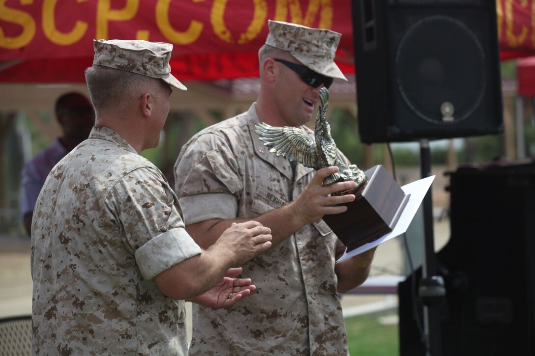 Chief Warrant Officer 2 Christopher Reighard, a meteorological and oceanographic officer with 3rd Marine Aircraft Wing, receives a leadership award at a family fun day aboard Marine Corps Base Camp Pendleton, Calif., July 1, 2015. The family fun day was hosted by 1st Intel Battalion and provided an opportunity for Marines and family members to celebrate their success and build camaraderie.