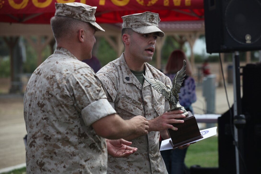 Sergeant Corwin Dimeo-Ediger, an intelligence specialist with 1st Intelligence Battalion, receives a leadership award at a family fun day aboard Marine Corps Base Camp Pendleton, Calif., July 1, 2015. The family fun day was hosted by 1st Intel Battalion and provided an opportunity for Marines and family members to celebrate their success and build camaraderie.