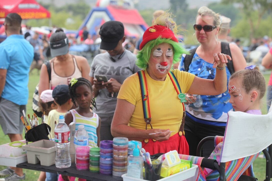 A clown paints Marine family members’ faces at the 1st Intelligence Battalion family fun day aboard Marine Corps Base Camp Pendleton, Calif., July 1, 2015. The family fun day allowed Marines and families of 1st Intel Battalion to celebrate their success and build camaraderie within the unit.
