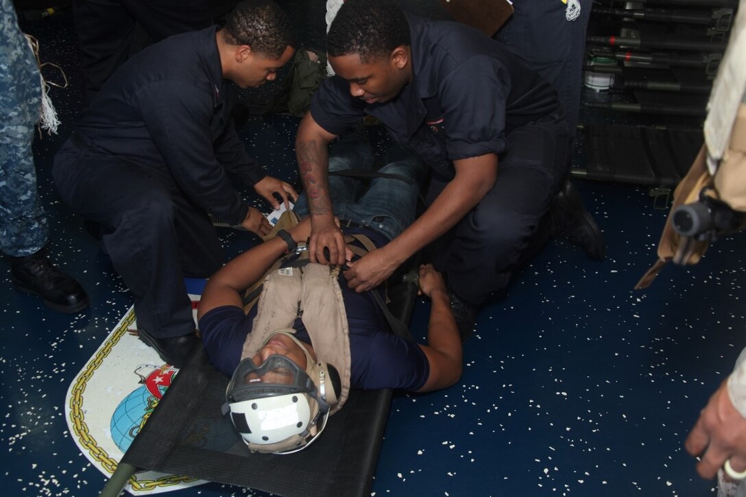 INDIAN OCEAN (July 20, 2015) U.S. Navy medical personnel assess the injuries to a simulated casualty aboard the amphibious assault ship USS Essex (LHD 2). Combat cargo Marines offloaded simulated casualties from an aircraft and brought them to the Essex’s medical staff for further care. Elements of the 15th MEU, based out of Camp Pendleton, California, and embarked aboard the Essex, are conducting naval operations in the 6th Fleet area of operations in support of U.S. national security interests in Europe and Africa. (U.S. Marine Corps photo by Staff Sgt. Miguel Carrasco/Released)