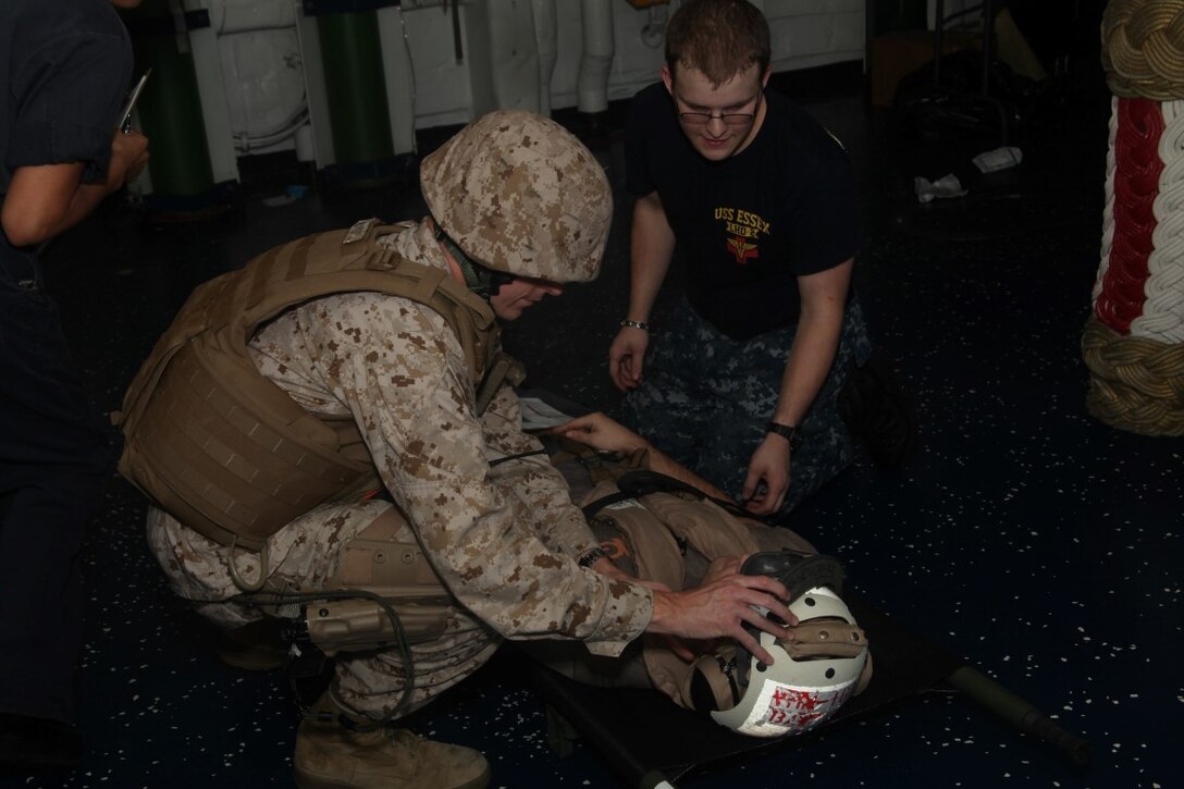 INDIAN OCEAN (July 20, 2015) U.S. Navy medical personnel injuries to a simulated casualty aboard the amphibious assault ship USS Essex (LHD 2). Combat cargo Marines offloaded simulated casualties from an aircraft and brought them to the Essex’s medical staff for further care. Elements of the 15th MEU, based out of Camp Pendleton, California, and embarked aboard the Essex, are conducting naval operations in the 6th Fleet area of operations in support of U.S. national security interests in Europe and Africa. (U.S. Marine Corps photo by Staff Sgt. Miguel Carrasco/Released)