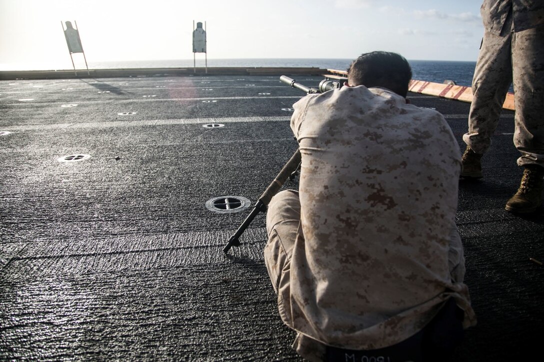 U.S. Marine Cpl. Roberto Sauceda shoots a sniper rifle during a deck shoot aboard the amphibious assault ship USS Essex (LHD 2). Sauceda is a point man with the scout sniper platoon, Weapons Company, Battalion Landing Team 3rd Battalion, 1st Marine Regiment, 15th Marine Expeditionary Unit (MEU). Elements of the 15th MEU, based out of Camp Pendleton, California, and embarked aboard the Essex, are conducting naval operations in the 6th Fleet areas of operation in support of U.S. national security interests in Europe and Africa. (U.S. Marine Corps photo by Cpl. Anna Albrecht/Released)