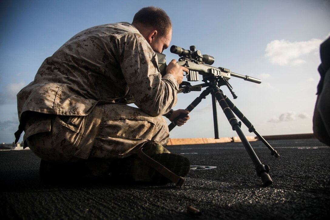 U.S. Marine Cpl. Mathew Becker adjusts his position before shooting a sniper rifle during a deck shoot aboard the amphibious assault ship USS Essex (LHD 2). Becker is an assistant team leader with scout sniper platoon, Weapons Company, Battalion Landing Team 3rd Battalion, 1st Marine Regiment, 15th Marine Expeditionary Unit (MEU).  Elements of the 15th MEU, based out of Camp Pendleton, California, and embarked aboard the Essex, are conducting naval operations in the 6th Fleet areas of operation in support of U.S. national security interests in Europe and Africa. (U.S. Marine Corps photo by Cpl. Anna Albrecht/Released)
