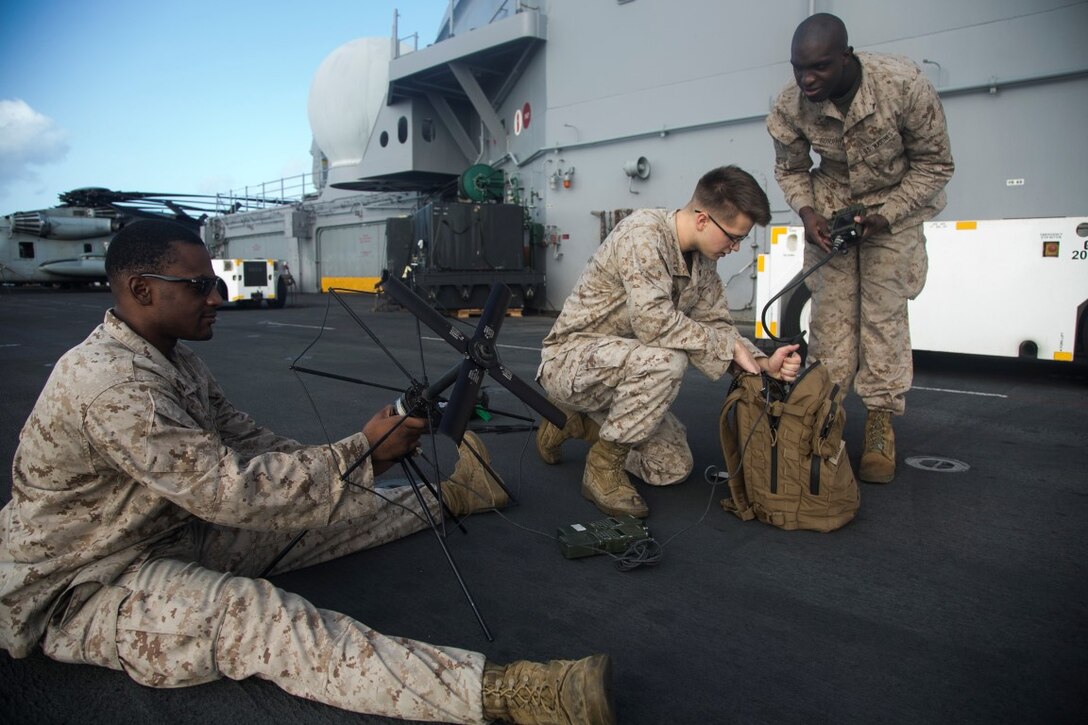 U.S. Marines with Headquarters and Support Company, Battalion Landing Team 3rd Battalion, 1st Marine Regiment,15th Marine Expeditionary Unit (MEU), test their satellite radios on the flight deck of the amphibious assault ship USS Essex (LHD 2). Elements of the 15th MEU, based out of Camp Pendleton, California, and embarked aboard the Essex, are conducting naval operations in the 6th Fleet area of operations in support of U.S. national security interests in Europe and Africa. (U.S. Marine Corps photo by Cpl. Anna Albrecht/ Released)