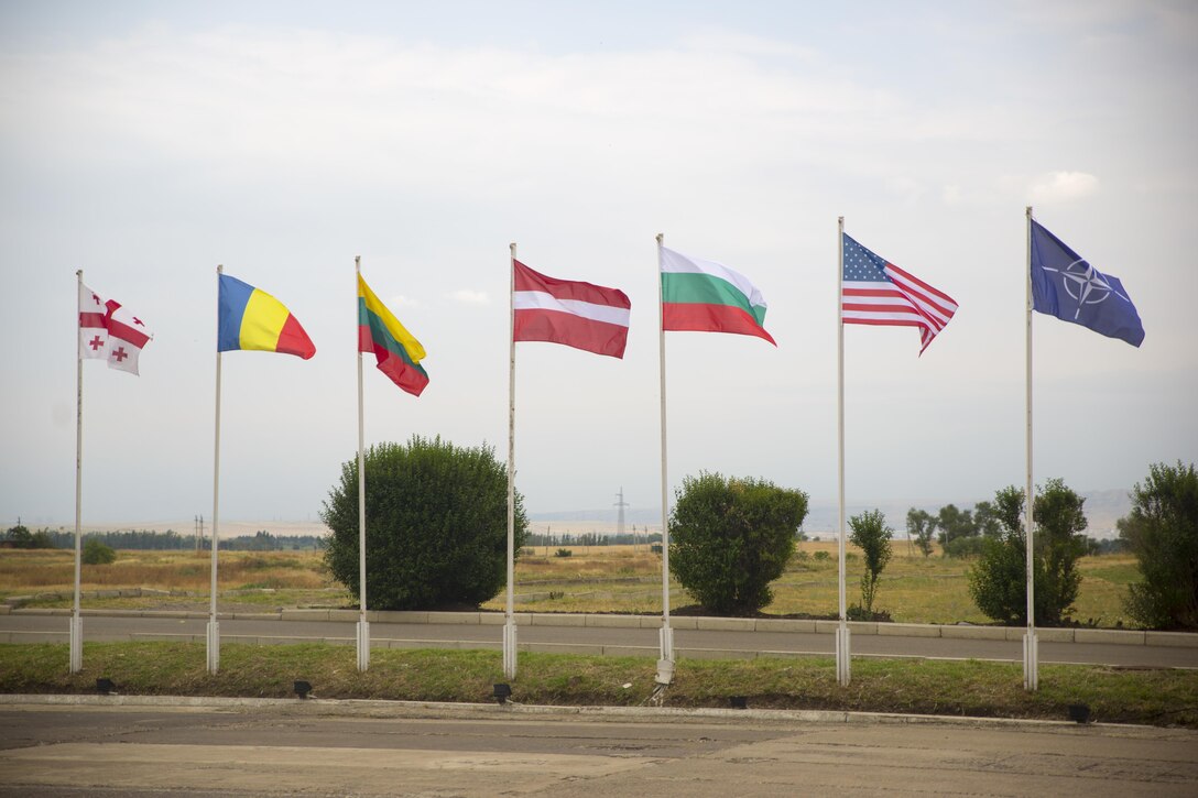 Georgian, Romanian, Lithuanian, Latvian, Bulgarian, United States of America and NATO flag fly together during the opening ceremony of Exercise Agile Spirit 15, July 8, 2015, at Vaziani, Georgia. Agile Spirit is an annual exercise involving a NATO Response Force level combined operation with participation from six allied and partner countries. (U.S. Marine Corps photo by Cpl. Ryan Young/ released)
