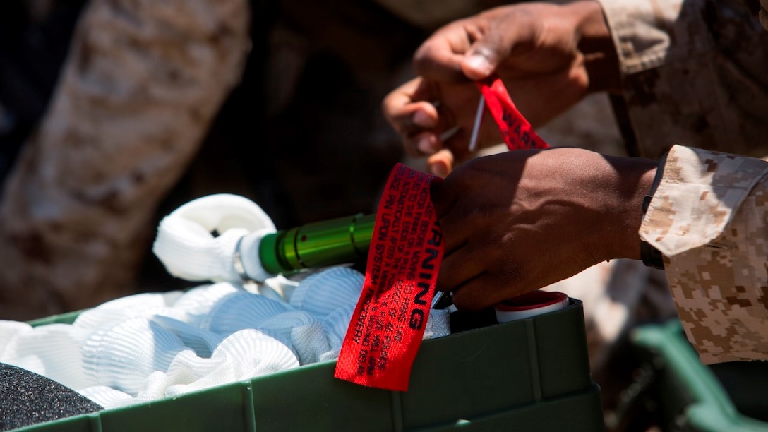 Lance Cpl. Oscar Egea, an assaultman with 1st Battalion, 3rd Marine Regiment, removes the safety pins from an Anti-personnel Obstacle Breaching System device during a live fire demolition range at Marine Corps Air Ground Combat Center Twentynine Palms, California, July 21. APOBS are used to conduct deliberate or hasty breaches through enemy anti-personnel minefields and multi-strand wire obstacles. 