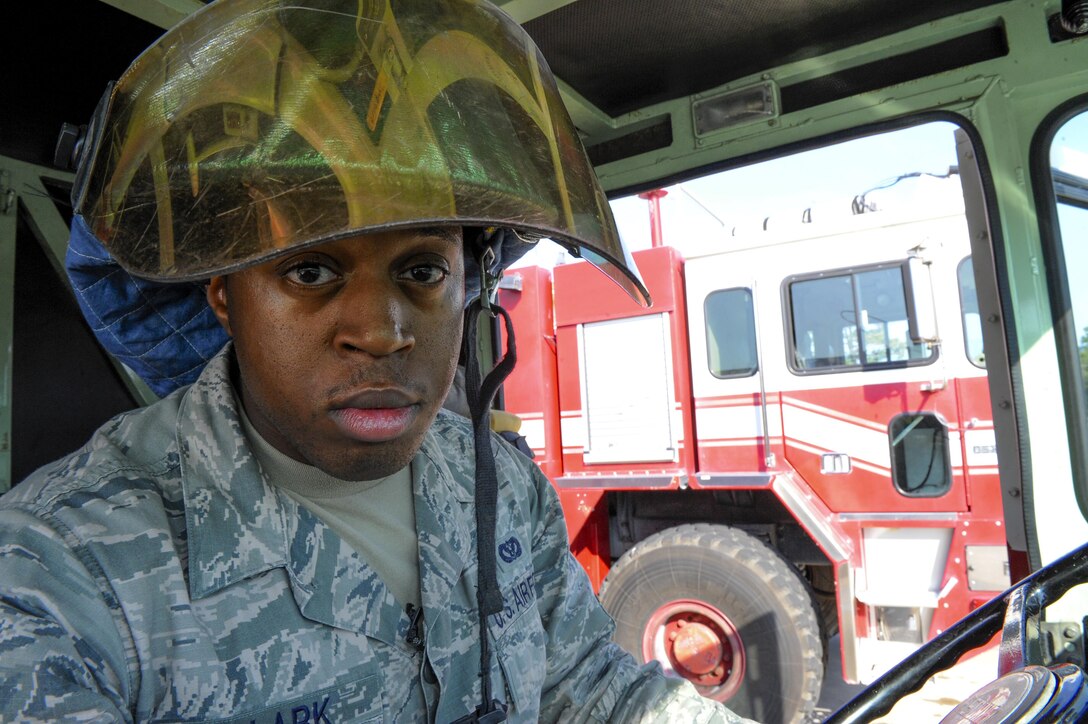 Senior Airman Montavious Clark, Fire Station #2 driver operator, tries on his helmet during a morning truck check at Eglin Air Force Base, Fla., July 22, 2015. Fire Station #2 conducts monthly familiarization training with the F-35 through the Academic Training Center, Air Force and Navy fighter squadrons. (U.S. Air Force Photo/Senior Airman Andrea Posey)