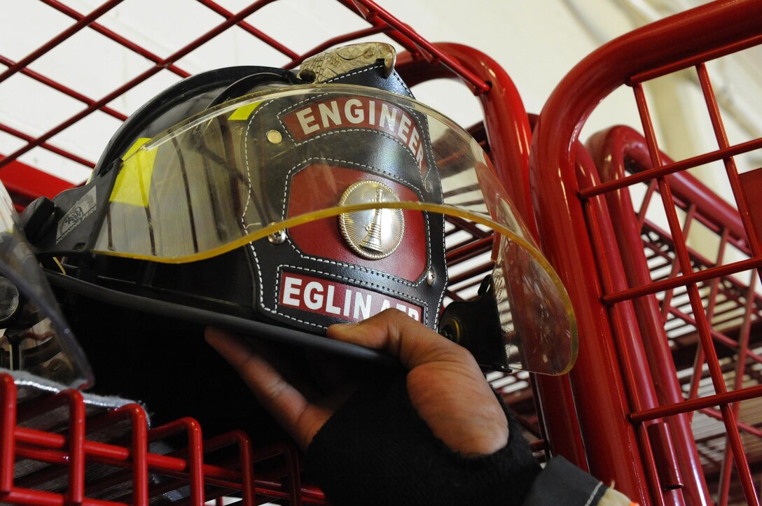 Senior Airman Montavious Clark, Fire Station #2 driver operator, takes his helmet out of his locker at Eglin Air Force Base Fla., July 22, 2015. Fire Station #2 conducts monthly familiarization training with the F-35 through the Academic Training Center, Air Force and Navy fighter squadrons. (U.S. Air Force Photo/Senior Airman Andrea Posey)