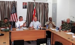 U.S. Army Lt. Col. Orson Ward, second from left, South Dakota Army National Guard, and U.S. Air Force Maj. Kevin Miller, center, South Dakota Air National Guard, participate in a subject matter expert exchange on strategic planning in Paramaribo, Suriname, July 15, 2015. 