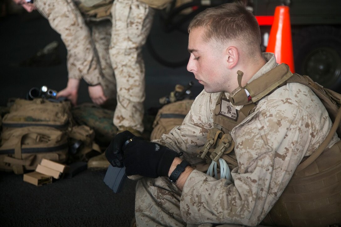 INDIAN OCEAN (July 21, 2015) A U.S. Marine with Lima Company, Battalion Landing Team 3rd Battalion, 1st Marine Regiment, 15th Marine Expeditionary Unit (MEU), loads rounds into a magazine during a quick reaction force rehearsal aboard the amphibious assault ship USS Essex (LHD 2). Elements of the 15th MEU, based out of Camp Pendleton, California, and embarked aboard the Essex, are conducting naval operations in the 6th Fleet area of operations in support of U.S. national security interests in Europe and Africa. (U.S. Marine Corps photo by Cpl. Anna Albrecht/Released)