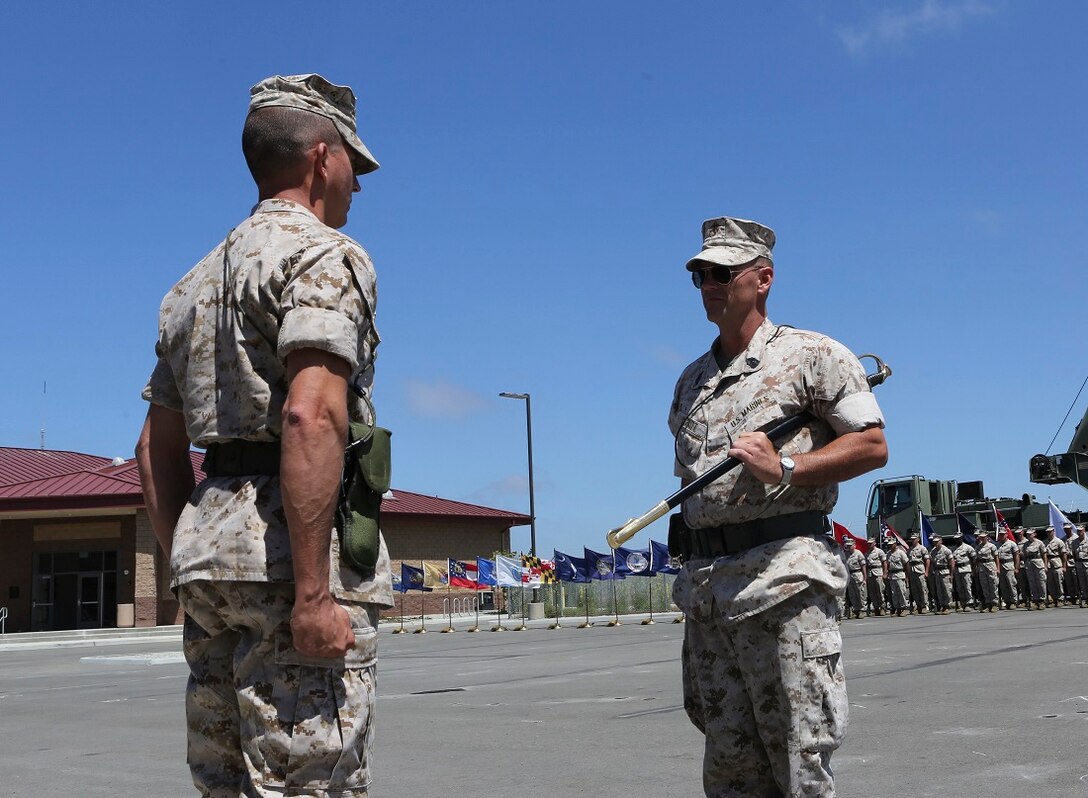 Sergeant Maj. Tracy D. Offutt, outgoing sergeant major, 1st Air Naval Gunfire Liaison Company, I Marine Expeditionary Force Headquarters Group, hands off the sword of office to Lt. Col. Brain E. Russell, retiring officer, July 16, during a ceremony aboard Marine Corps Base Camp Pendleton, Calif. Offutt retired from the Marine Corps after 29 years of honorable service.