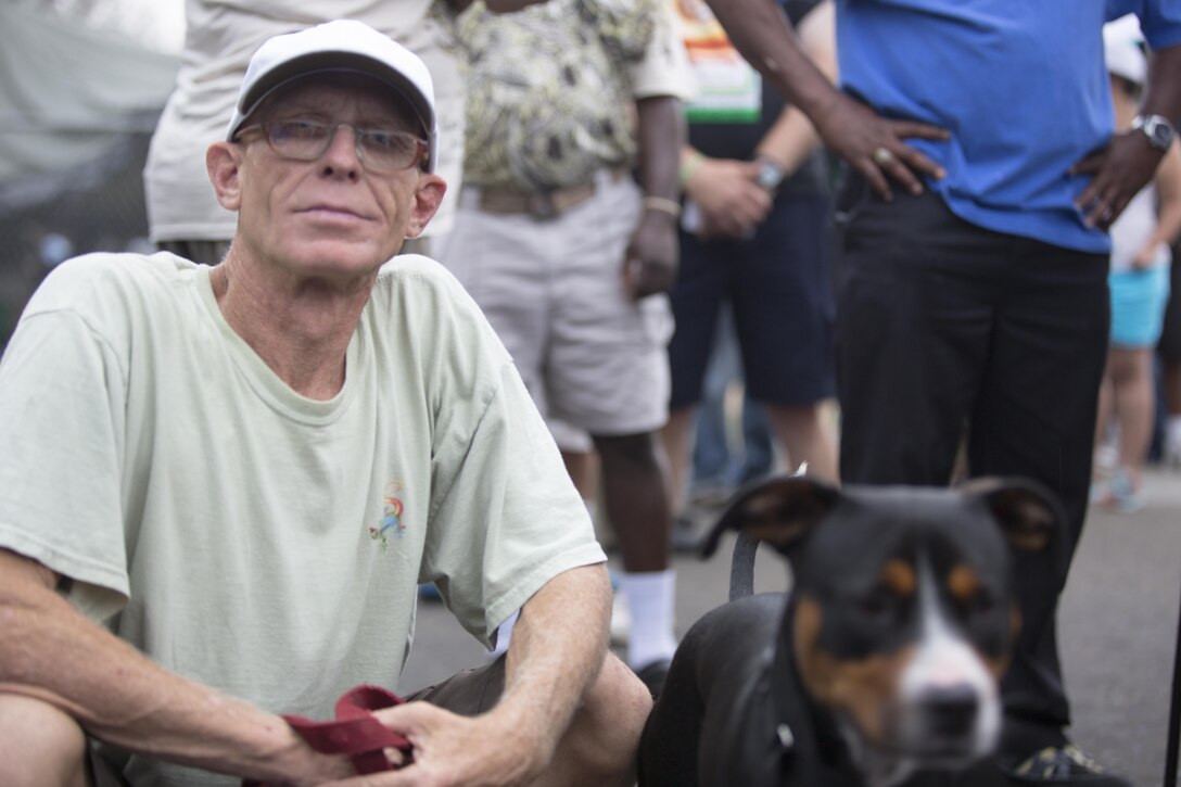 Hayden Sumner, a Navy veteran who served in the Persian Gulf and native of Houston, Texas, waits in line with his dog, Durant, at the San Diego Stand Down for Homeless Veterans and their families in San Diego, July 18. marines with Marine Wing Support Squadron 373 from Marine Corps Air Station Miramar transported, set-up and maintained the tents and other equipment used during the stand down. (U.S. Marine Corps photo by Sgt. Lillian Stephens)