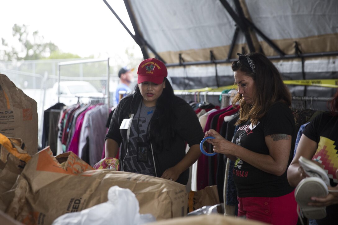 Two volunteers from the Rockabilly Mafia Dolls organize clothing during the San Diego Stand Down for Homeless Veterans and their families, July 18. Marine Wing Support Squadron 373 from Marine Corps Air Station Miramar, California transported, set-up and maintained the tents and other equipment used during the stand down. (U.S. Marine Corps photo by Sgt. Lillian Stephens)