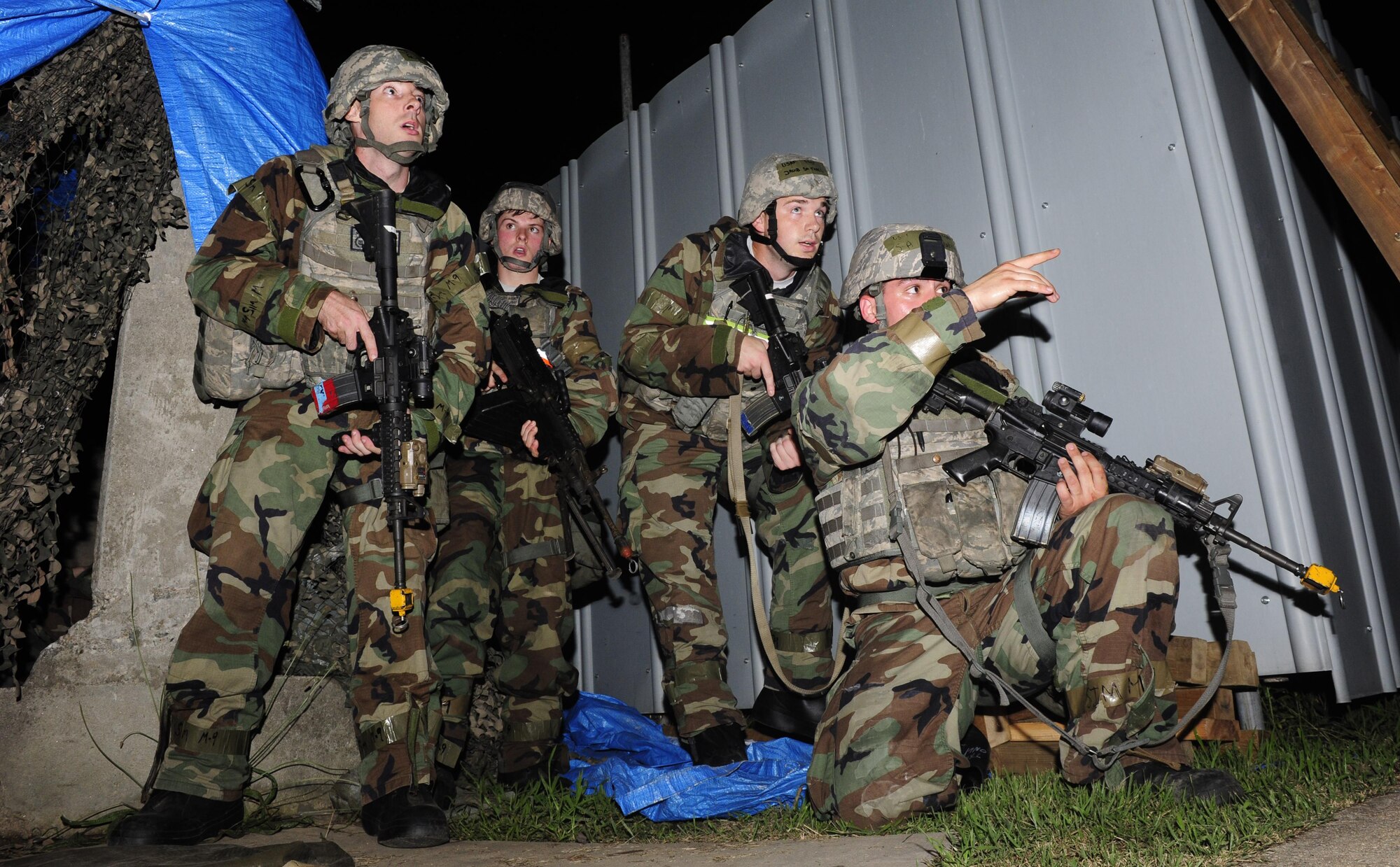 U.S. Air Force Airmen from the 8th Security Forces Squadron discuss procedures before engaging hostile forces in response to an exercise ground attack on an 8th Communications Squadron compound during Exercise Beverly Midnight 15-4 at Kunsan Air Base, Republic of Korea, July 15, 2015. BM 15-4 tested Airmen on their ability to survive and operate while under the stress of simulated wartime activities. (U.S. Air Force photo by Staff Sgt. Nick Wilson/Released)
