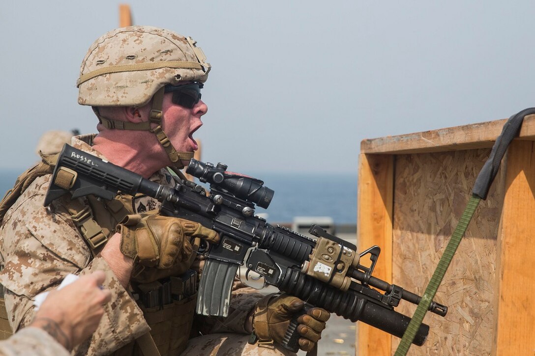 ARABIAN GULF (July 22, 2015) U.S. Marine Cpl. Curtis Russell shouts an alert with direction, description, range, assignment and control to his fire team during a short-range marksmanship qualification course aboard the dock landing ship USS Rushmore (LSD 47). Russell is a is team leader with Kilo Company, Battalion Landing Team 3rd Battalion, 1st Marine Regiment, 15th Marine Expeditionary Unit. The marksmanship course focused on improving Marine’s communication during combat shooting, as well as immediate action tactics, which prepare them for potential operations while deployed with the 15th MEU. The 15th MEU is embarked on the Essex Amphibious Ready Group and is deployed to maintain regional security in the U.S. 5th Fleet area of operations. (U.S. Marine Corps photo by Sgt. Emmanuel Ramos/Released)