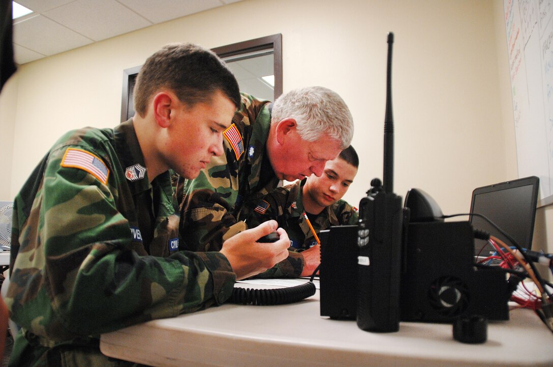 Lt. Col. James Card, (center), assistant director of communications and licensing officer, Georgia Wing Civil Air Patrol, teaches young cadets how to use communication equipment during Georgia Wing CAP’s weeklong summer encampment at Marine Corps Logistics Base Albany, July 21-25.