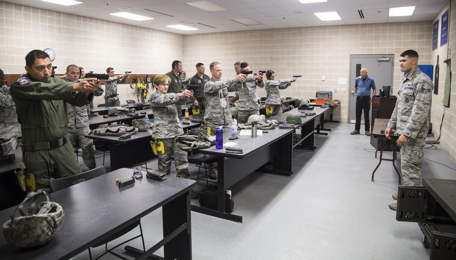 Students in the weapons qualification course practice aiming their Beretta M9 pistols while Senior Airman Cory Irvin, 37th Training Squadron combat arms instructor, makes corrections July 6 at the Joint Base San Antonio-Lackland Medina Annex. Combat Arms Training and Maintenance program instructors teach a variety of student audiences, including both JBSA-Lackland and JBSA-Fort Sam Houston security forces members, military individuals who are deploying or renewing training during a permanent change of station, and all Air Force Basic Military Training trainees. Both Tactical Air Control Party and Combat Control technical school students also fulfill weapons training requirements with the 37th TRS. 