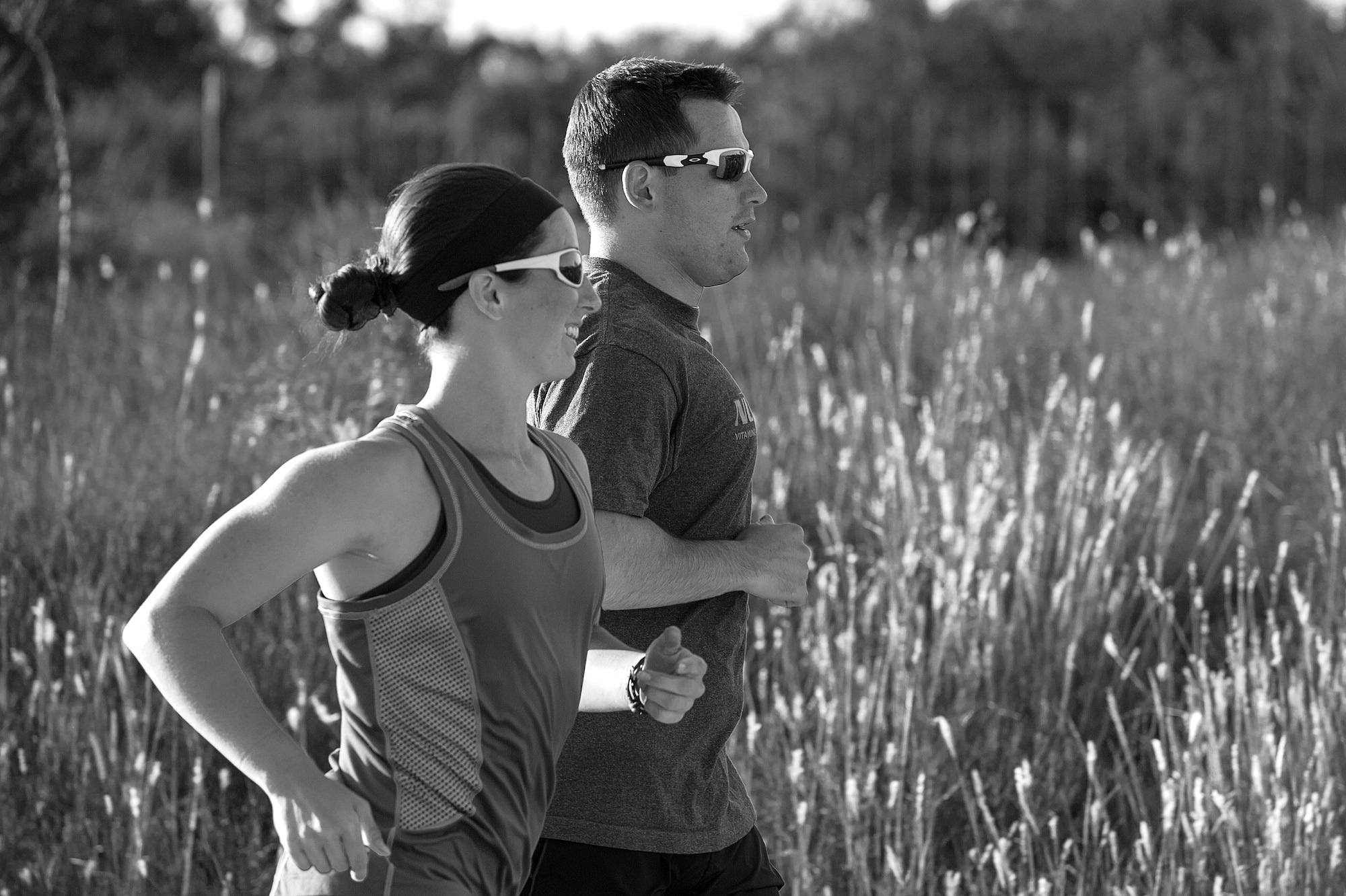 U.S. Air Force 1st Lt. Morgan K. Diglia, Sexual Assault Response Coordinator deputy, runs with her husband during a triathlon training session in San Angelo, Texas, July 22, 2015. Diglia is prepping for an olympic triathlon, which includes a 1.5km swim, 40km bike ride, and a 10km run. (U.S. Air Force photo by Staff Sgt. Michael Smith/Released)