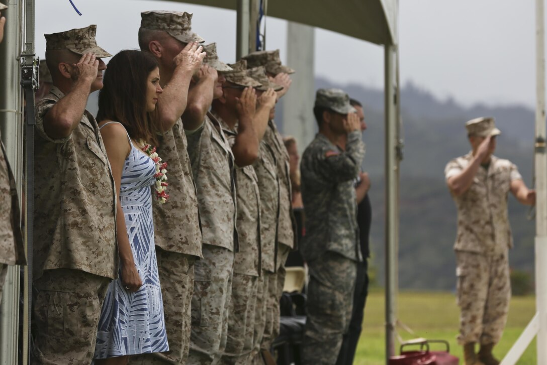 U.S. Military members salute during the playing of the National Anthem at the change of command on Camp H. M. Smith, Hawaii, July 24, 2015. During the ceremony, Col Darric M. Knight relinquished his duties as Marine Corps Forces, Pacific Headquarters and Service Battalion Commanding Officer to Col. Peter S. Gadd.