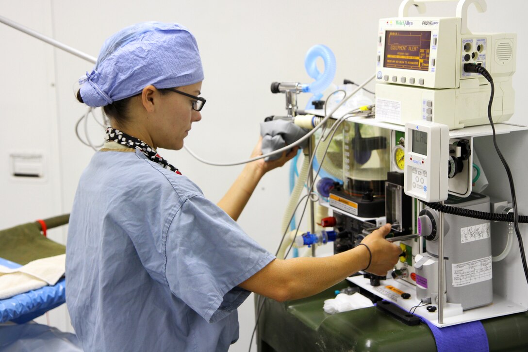 U.S. Army Reserve Lt. Awilda Rodriguez inspects her equipment before performing veterinary
