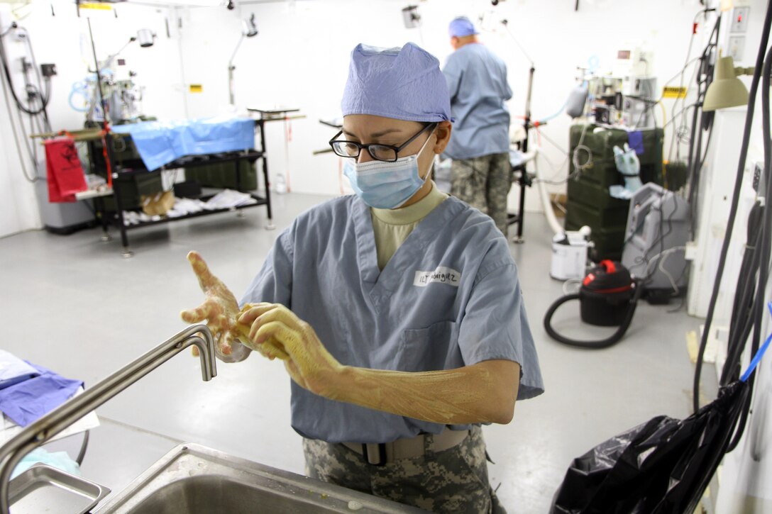 U.S. Army Reserve Lt. Awilda Rodriguez washes her hands before performing veterinary services