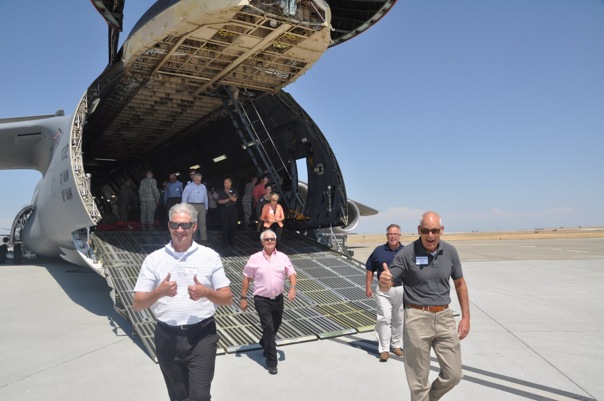Kevin Twohig, Spokane Public Facilities CEO, 336th Training Group honorary commander and chair of Forward Fairchild, and Dr. Brad Pope, Regional Group Health Medical Director, 92nd Medical Group honorary commander, show enthusiasm after viewing a C-5 Galaxy. More than 20 civic leaders from Spokane, Wash. and surrounding areas participated in a tour to Travis Air Force Base, Calif. July 21 and 22. 