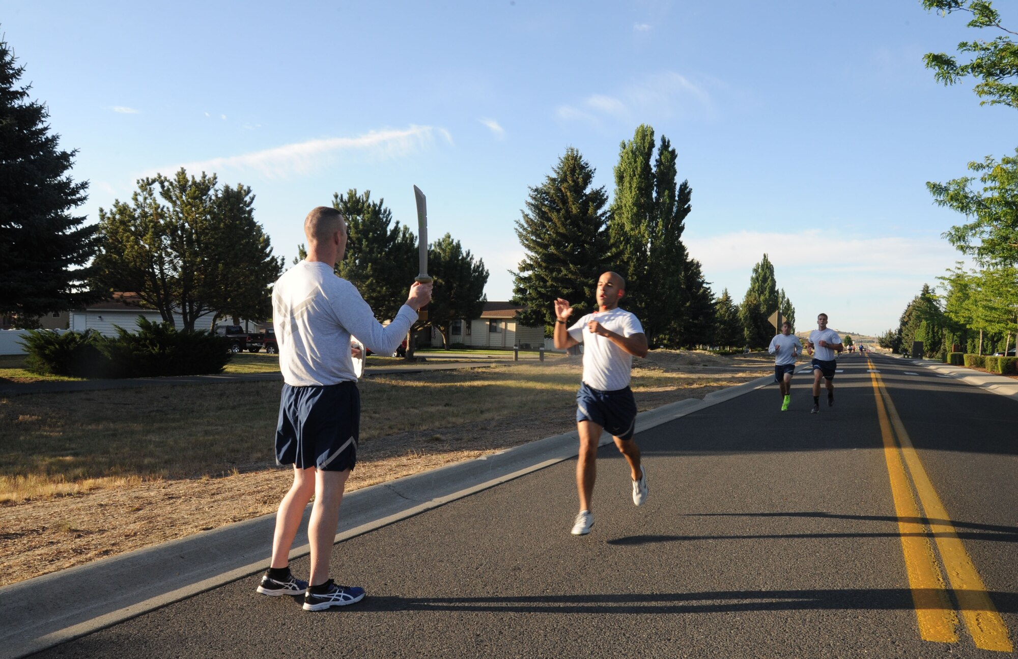 Airmen are greeted with a sword upon completion of the wing run July 24, 2015, at Fairchild Air Force Base, Wash. The course was a two-mile run that went around the “Hospital Loop.” (U.S. Air Force photo/Senior Airman Sam Fogleman)
