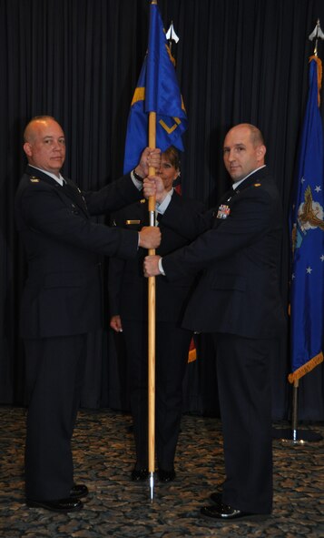NAVAL AIR STATION FORT WORTH JOINT RESERVE BASE, Texas - Col. Jeffrey Barnett, 301st Mission Support Group commander, hands the 301st Logistics Readiness Support guidon to  Maj. Kristofer Johnston, its new squadron commander, during a change of command ceremony here July 11 while Master Sgt. Mary Staffeld, 301 LRS first sergeant, watches.(U.S. Air Force photo by Staff Sgt. Lydia Prieto)