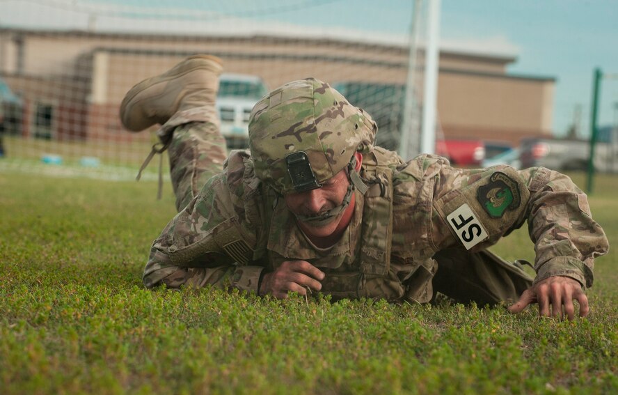 Airman 1st Class Jesse Daniel, 5th Security Forces Squadron member, low crawls through the grass at the McAdoo Sports and Fitness Center during tryouts for his squadron’s Global Strike Challenge Competition team at Minot Air Force Base, N.D., July 23, 2015. Daniel finished both phases of the tryouts first and received a final time of 50 minutes 23 seconds. (U.S. Air Force photo/Senior Airman Stephanie Morris)