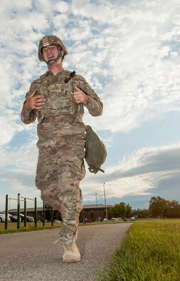 Airman 1st Class Daniel D’Ambrosio, 5th Security Forces Squadron member, adjusts his plate carrier during the first running phase of tryouts for his squadron’s Global Strike Challenge Competition team at Minot Air Force Base, N.D., July 23, 2015. D’Ambrosio ran a mile and a half in his full gear and helmet before donning a gas mask for the next run. (U.S. Air Force photo/Senior Airman Stephanie Morris)