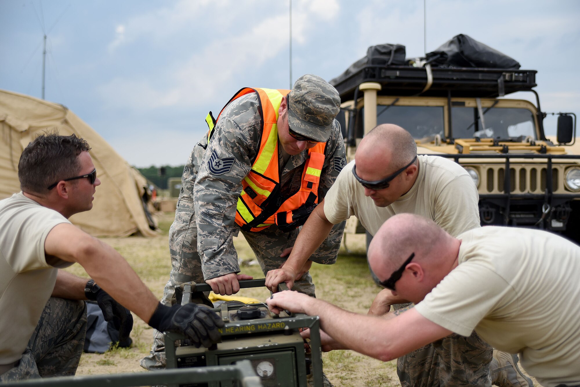 Technical Sgt. Robert Grimes(center), 421st Combat Training Squadron, assists Capt. Kaleb Bury, Capt. Jacob Becker, and Senior Airman Jake Thompson, all of 921st Contingency Response Squadron, with repairing a generator fuel line at Joint Base McGuire-Dix-Lakehurst, New Jersey, on July 21, 2015. Grimes, the Exercise Turbo Distribution site coordinator, supports the assessment of the visiting units’ ability to secure the compound and maintain the safety of participants. TD 15-7, a Joint Task Force-Port Opening (JTF-PO) field training exercise, hosted by the U.S. Air Force Expeditionary Center at Joint Base McGuire-Dix-Lakehurst, New Jersey, tests the ability to rapidly deploy and employ a JTF-PO Aerial Port of Debarkation (APOD) enabling capability in direct support to a regional combatant command. (U.S. Air Force photo/Danielle Brooks)
