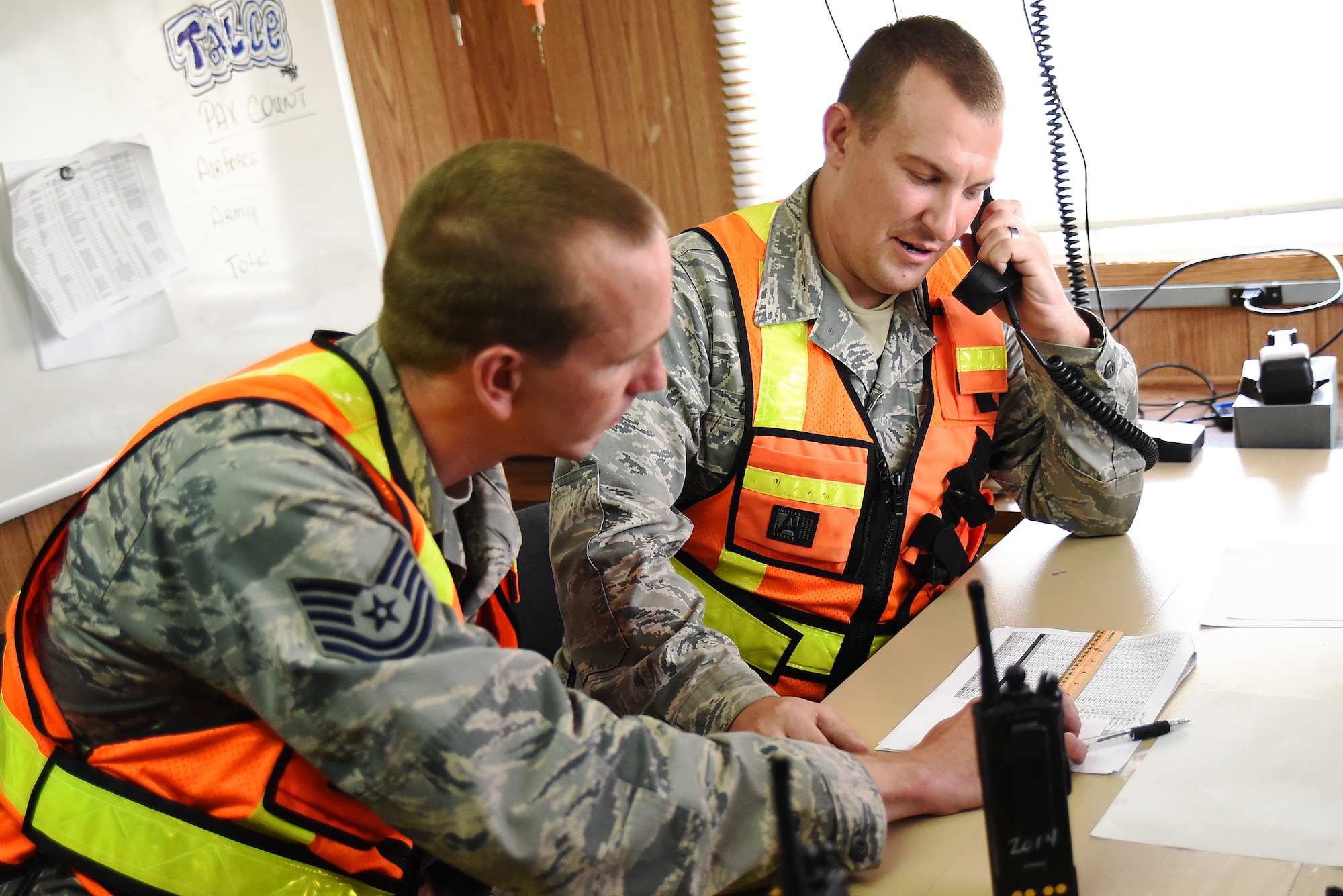 Technical Sgt. Robert Leppla and Staff Sgt. Brian Gifford, both of the 421st Combat Training Squadron, act as aircraft dispatchers during Exercise Turbo Distribution 15-7 at Joint Base McGuire-Dix-Lakehurst, New Jersey, on July 21, 2015. They coordinate with both aircraft and ground crews participating in the exercise to land and off load cargo. TD 15-7, a Joint Task Force-Port Opening (JTF-PO) field training exercise, hosted by the U.S. Air Force Expeditionary Center at Joint Base McGuire-Dix-Lakehurst, New Jersey, tests the ability to rapidly deploy and employ a JTF-PO Aerial Port of Debarkation (APOD) enabling capability in direct support to a regional combatant command. (U.S. Air Force photo/Danielle Brooks)