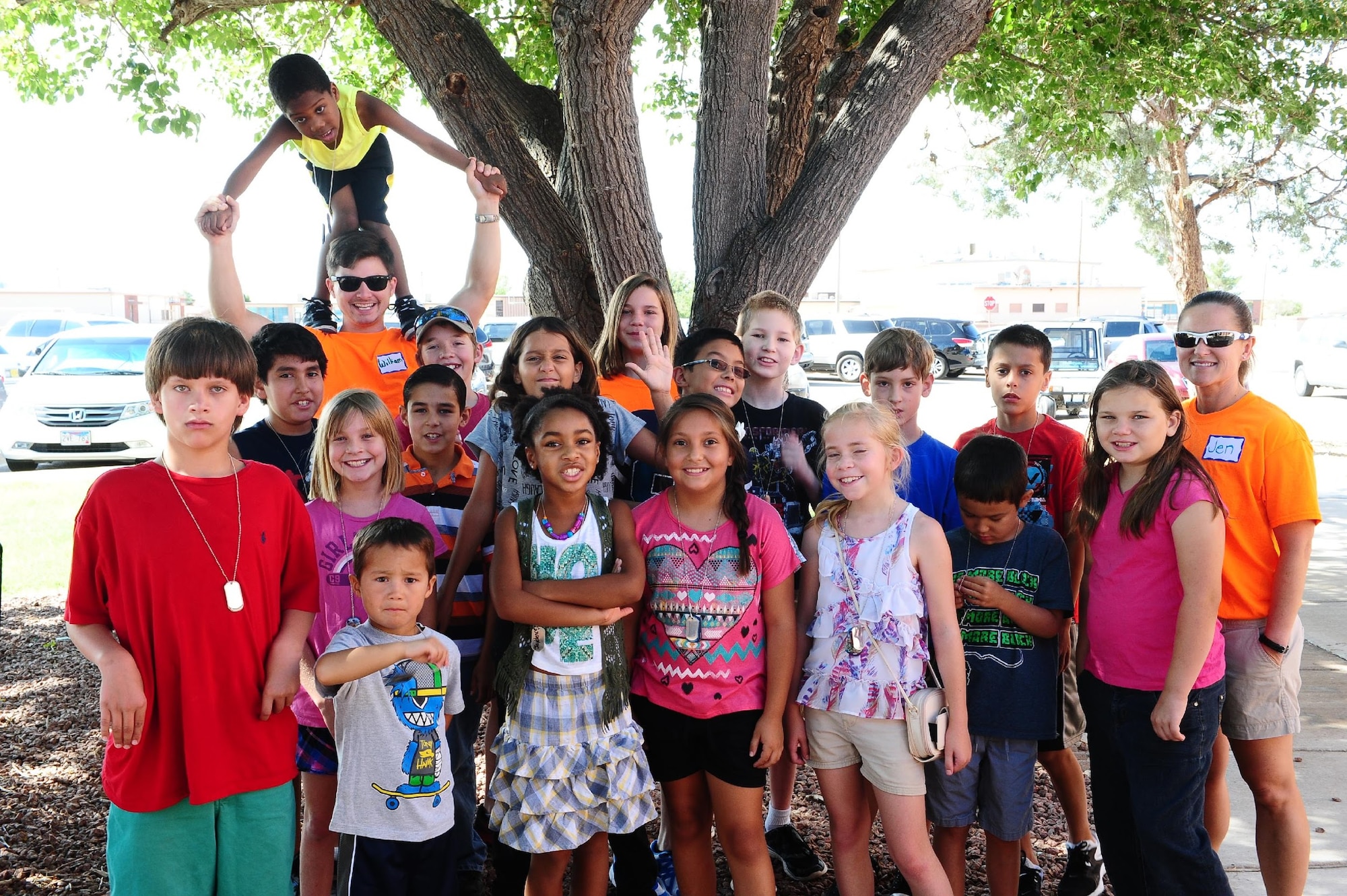 Volunteers in orange T-shirts and children participating in this year’s vacation bible school take a break from their game to pose for a picture outside the chapel July 21. This year’s theme, Mt. Everest, took the work of over 30 volunteers and hosted more than 100 children. (U.S. Air Force photo by Amn Randahl J. Jenson)