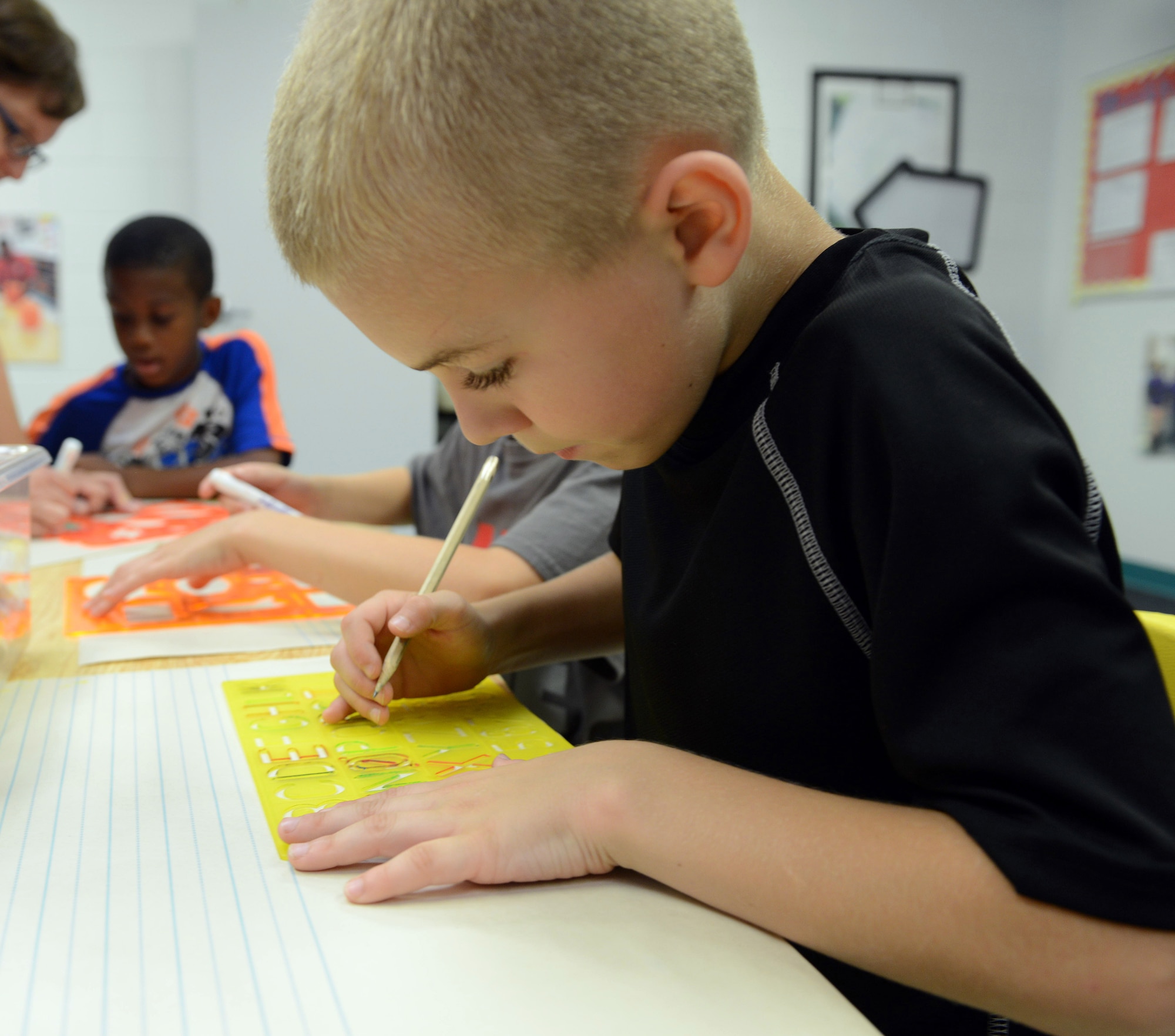 Eight-year-old Aaron Franklin creates artwork with a group of students at the center. . (U.S. Air Force photo by Tommie Horton)
