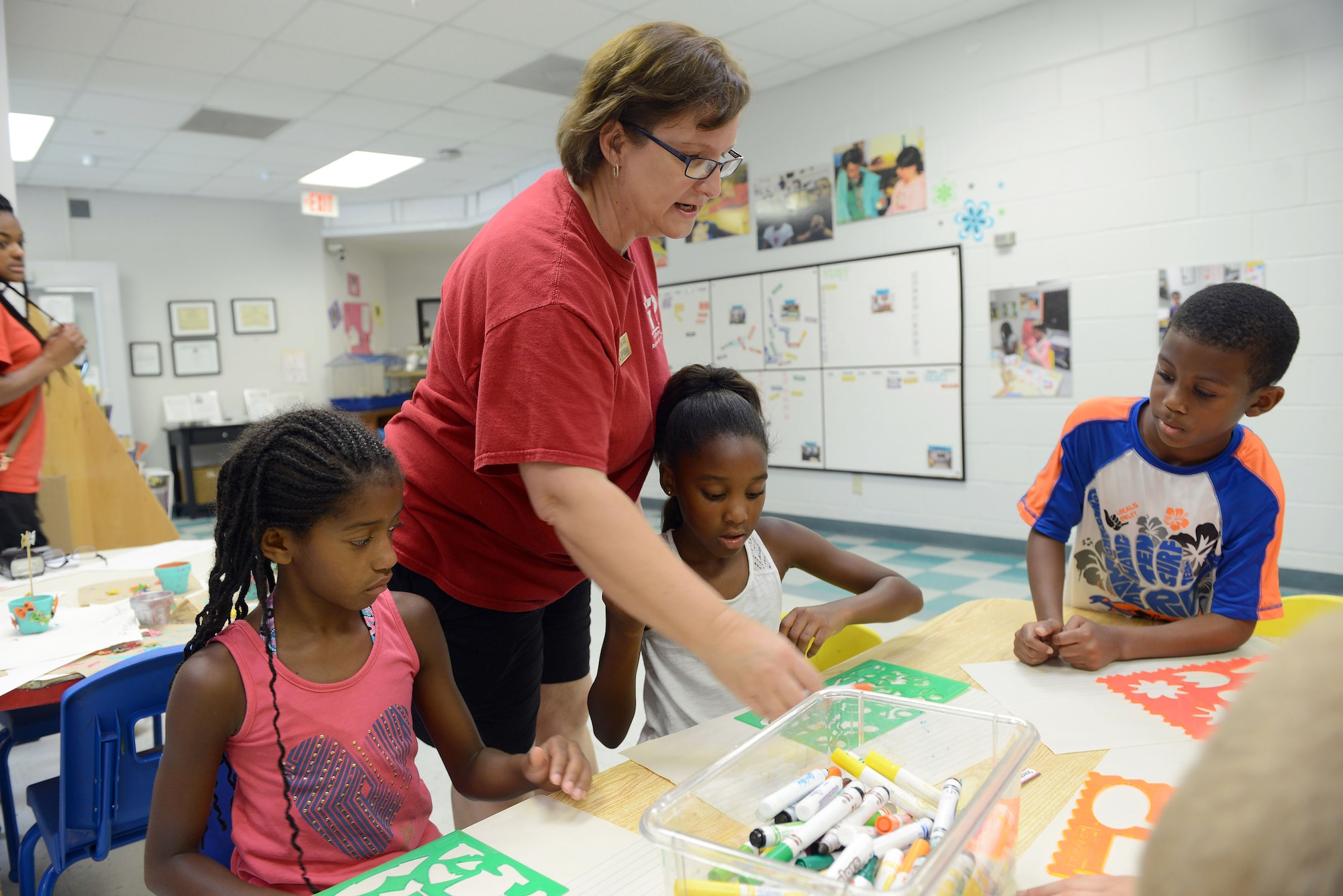 Marcia Gill, Robins Youth Center program assistant, leads activities for a group of youth at the facility. Beginning Aug. 3, the center will offer before-and after-school care for children between 5 and 12 years of age. (U.S. Air Force photo by Tommie Horton)