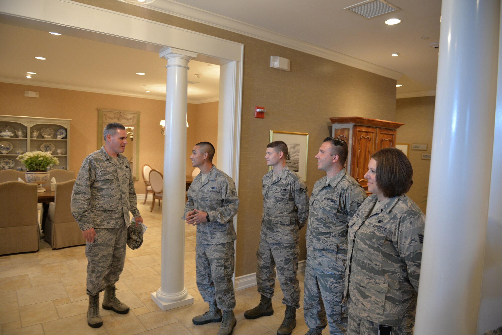 Brig. Gen. Lenny Richoux, Director of Services, Headquarters Air Force, talks with Senior Airman Cody Rodriguez, Fisher House for the Families of the Fallen manager on duty, Dover Air Force Base, Del., during the general's orientation July 21, 2015. Rodriguez is deployed to the mortuary from the 512th Memorial Affairs Squadron. The facility consists of nine suites and can lodge as many as 32 family members traveling to Dover to witness the dignified transfer of a loved one.  (U.S. Air Force photo by Senior Airman Robert Gunn)