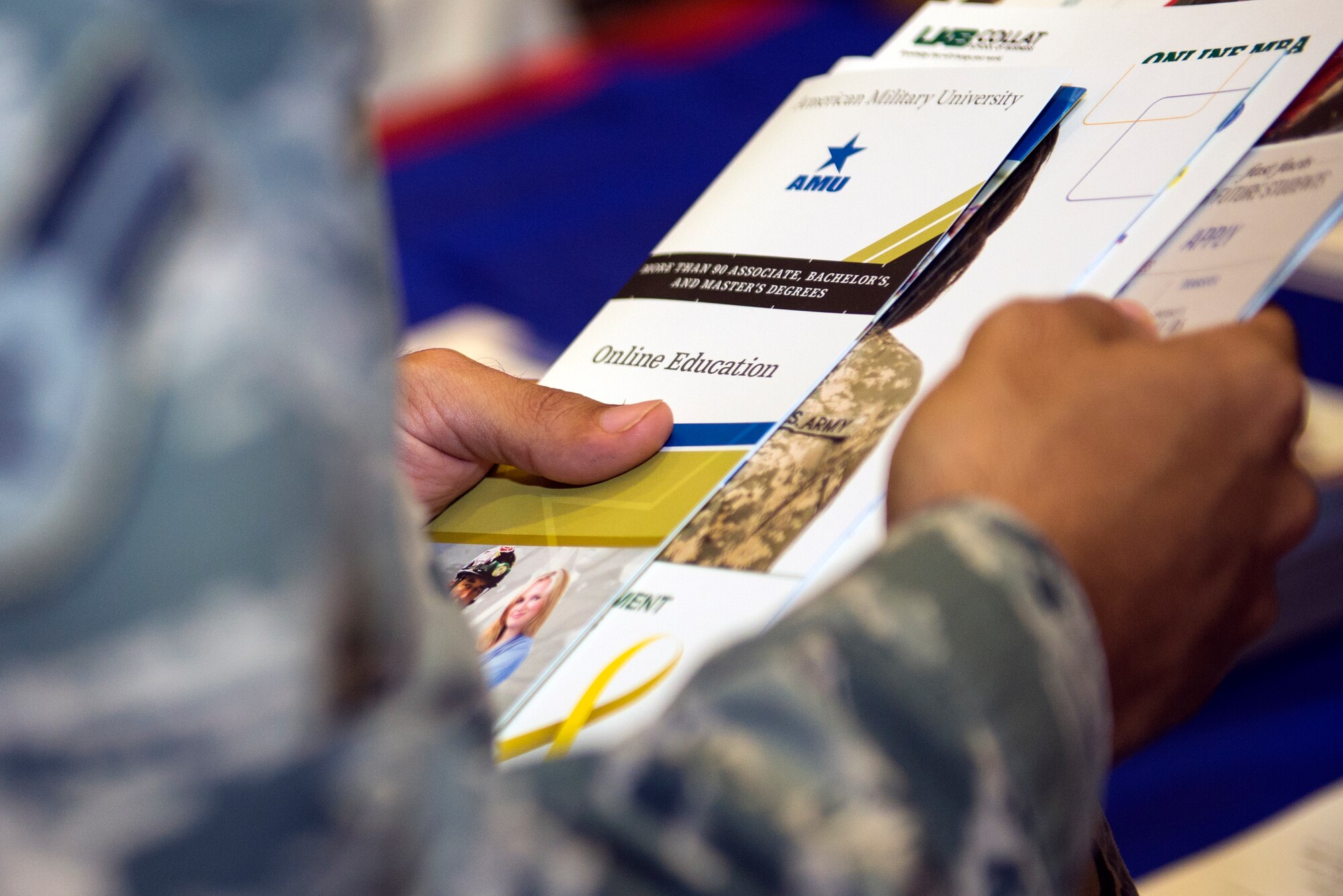 U.S. Air Force Airman 1st Class Ronald Anazco, 23d Equipment Maintenance Squadron nondestructive inspector, holds brochures from various institutions at the National Education Fair July 22, 2015, at Moody Air Force Base, Ga. Approximately 180 attendees sought after higher educational opportunities while receiving information such as utilizing tuition assistance and completing Community College of the Air Force degrees. (U.S Air Force photo by Airman Greg Nash/Released)  