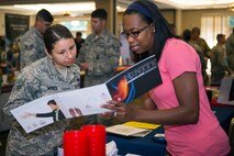 Marci Marshall, (right), academic services professional, goes over a program guide with U.S. Air Force Airman 1st Class Selina Mance, 23d Force Support Squadron command section administrator, during the National Education Fair July 22, 2015, at Moody Air Force Base, Ga. Education representatives offered attendees an array of options on obtaining higher education while providing information on general courses, electives and semester hours required to complete their programs. (U.S. Air Force photo by Airman Greg Nash/Released) 
